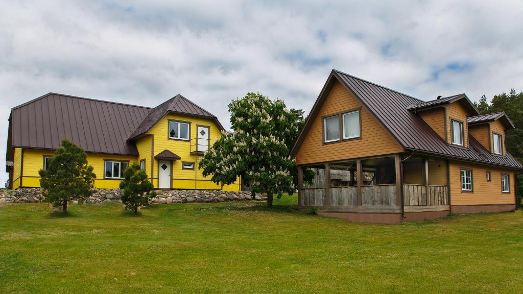 a large yellow house with a black roof at Risti kodumajutus in Lemsi
