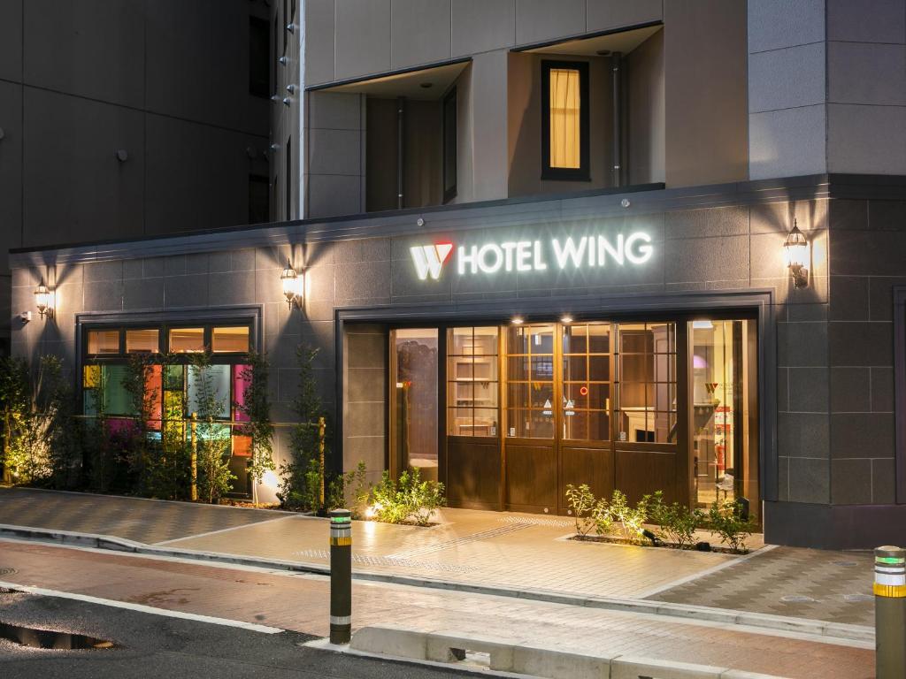 東京的住宿－Hotel Wing International Select Ikebukuro，酒店大楼,上面有标牌,上面写着酒店翼楼