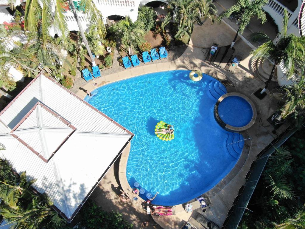 an overhead view of a large swimming pool with a umbrella at Hotel Mar Rey in Tamarindo