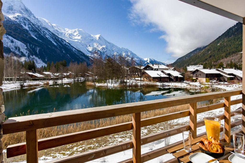 a view of a lake from a balcony with snow covered mountains at La Cordee 612 apartment- Chamonix All Year in Chamonix-Mont-Blanc