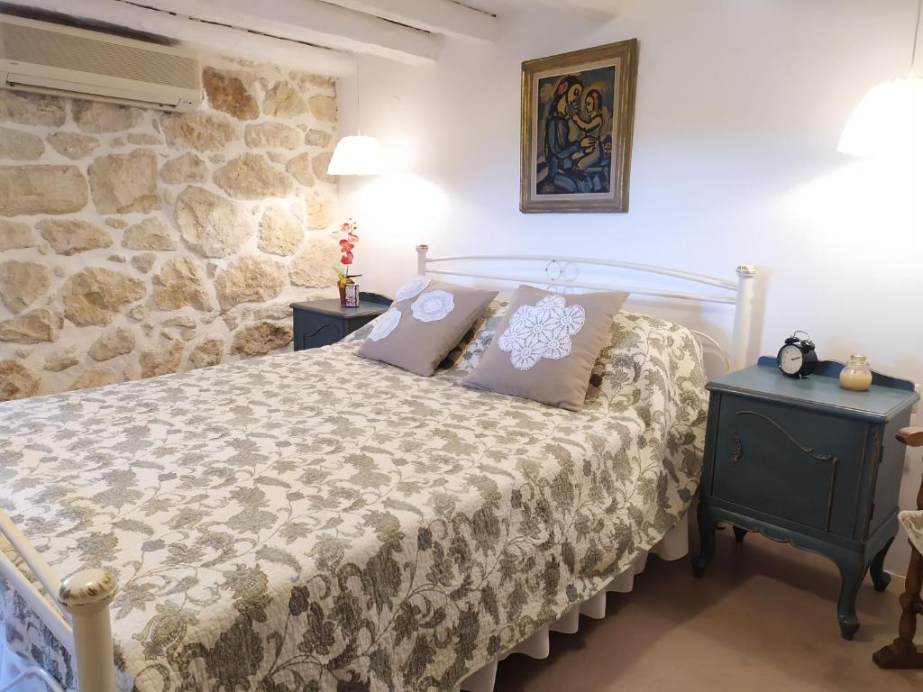 a bedroom with a bed and a stone wall at Cozy stone house in Sikéa