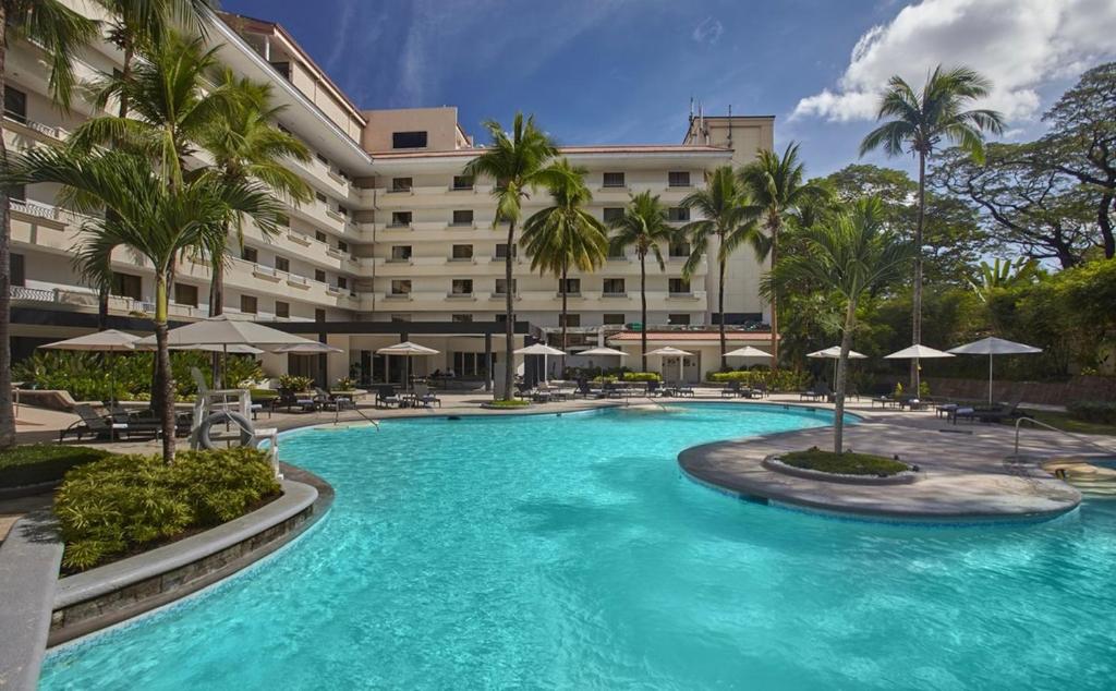 a swimming pool in front of a hotel at Quest Plus Conference Center, Clark in Clark