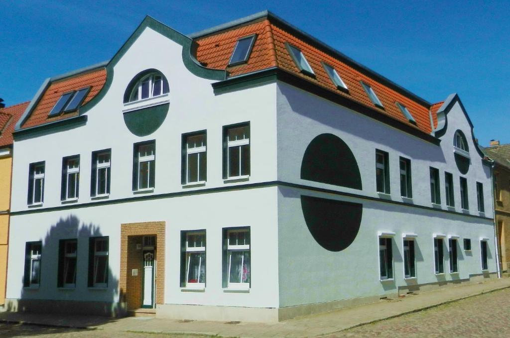 een groot wit gebouw met een rood dak bij Haus am Eichenwall, Fewo1, Residenz + Ferienwohnungen in Friedland