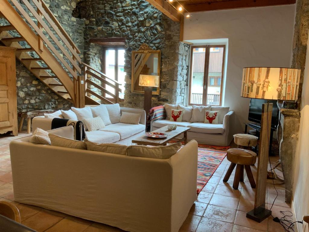 a living room with couches and a piano at Maison du Bourg in Samoëns