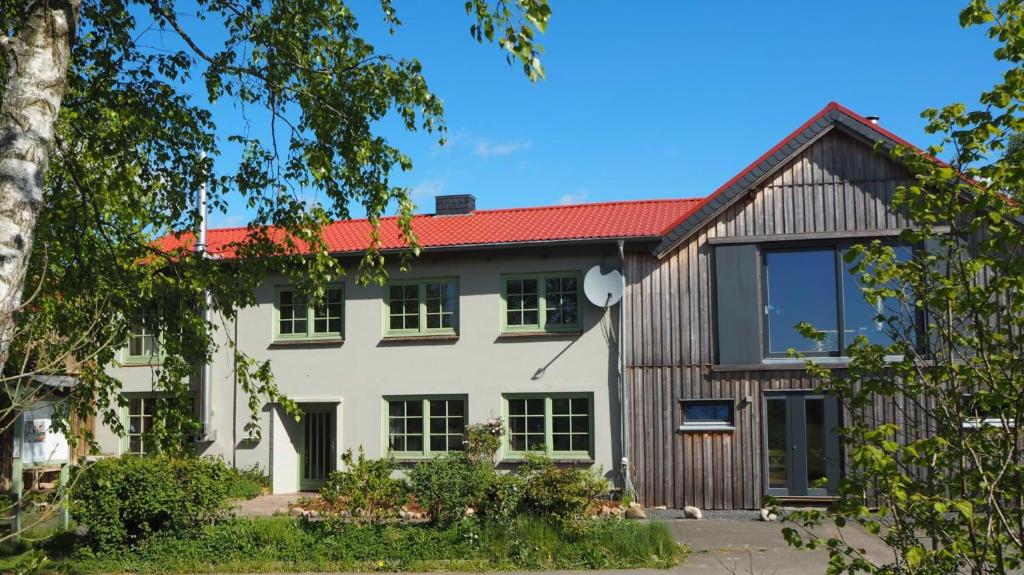une maison avec un toit rouge dans l'établissement Schwanenhof (OG), à Brodersby