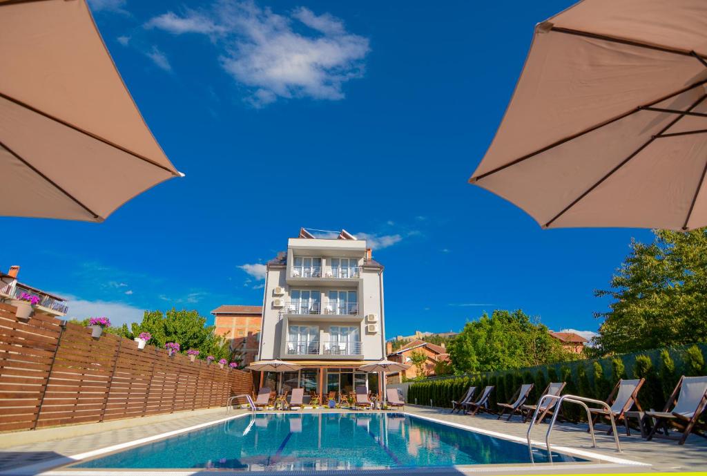 um hotel com piscina em frente a um edifício em Villa Kotlar em Ohrid