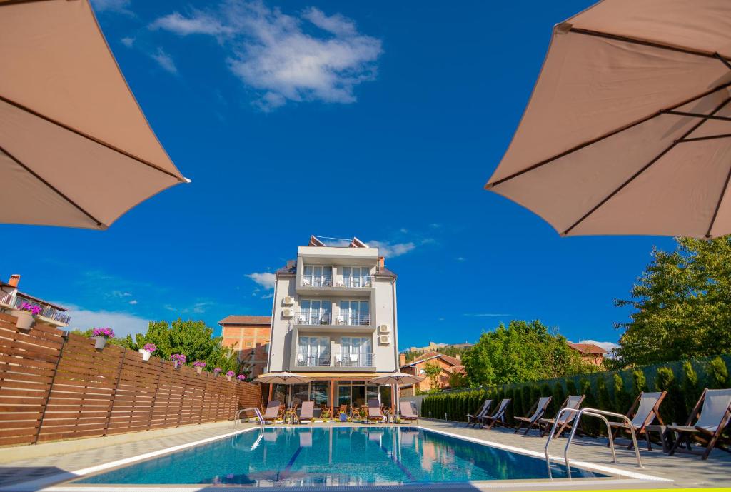 a hotel with a swimming pool in front of a building at Villa Kotlar in Ohrid