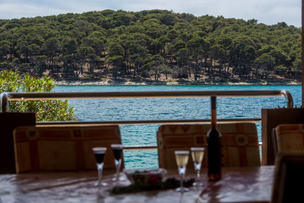 a table with wine glasses and a view of the water at Holiday home Nostalgija in Brgulje