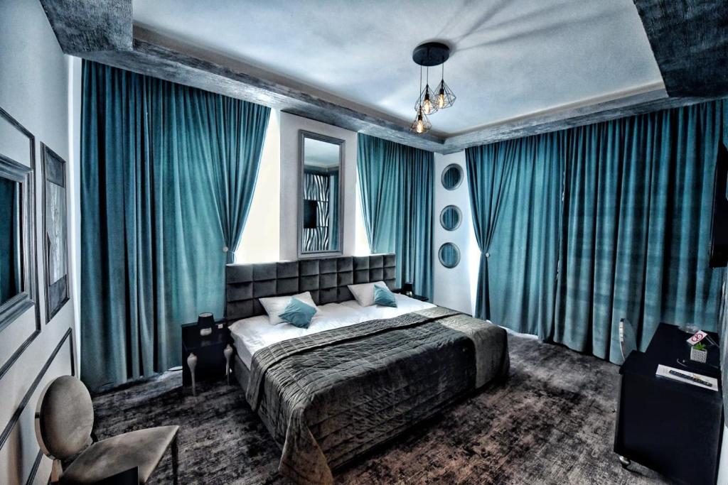 a bedroom with a bed with blue drapes at Hotel Bellavista Deta in Deta