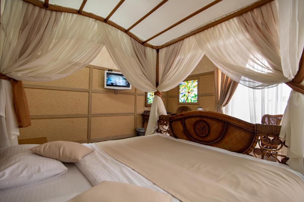 ein Schlafzimmer mit einem großen Bett mit Baldachin in der Unterkunft Aqvium in Dnipro