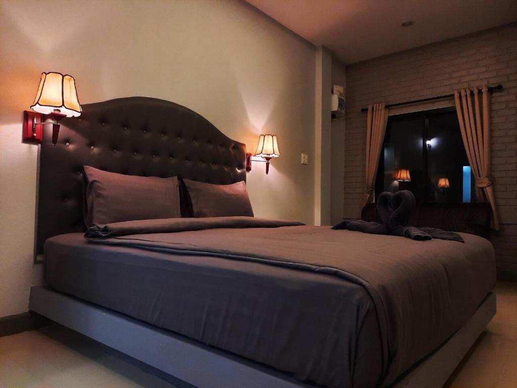 a bedroom with a large bed with two lamps at Home resort in Phitsanulok