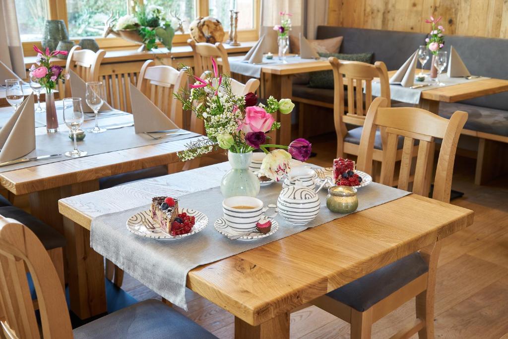 a table in a restaurant with flowers on it at Hotel Klosterhotel Ludwig der Bayer in Ettal