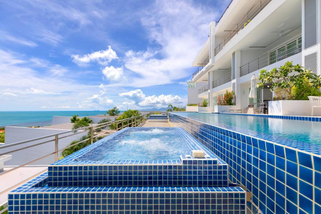 a swimming pool with a view of the ocean at Unique Boutique Residences in Bang Rak Beach