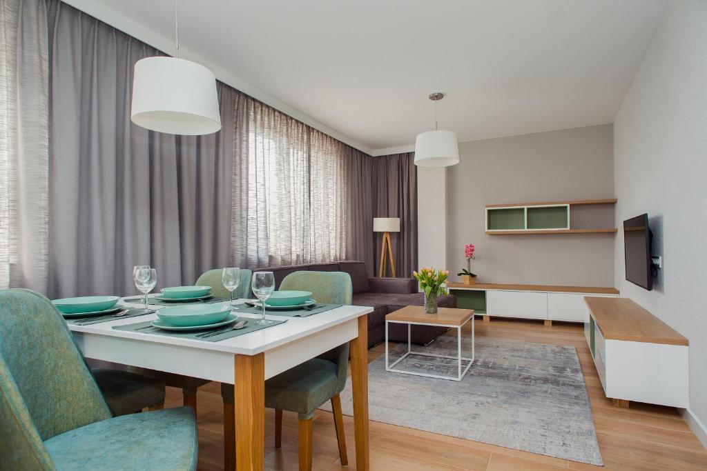 een eetkamer en een woonkamer met een tafel en stoelen bij ShortStayPoland Apartamenty in Warschau