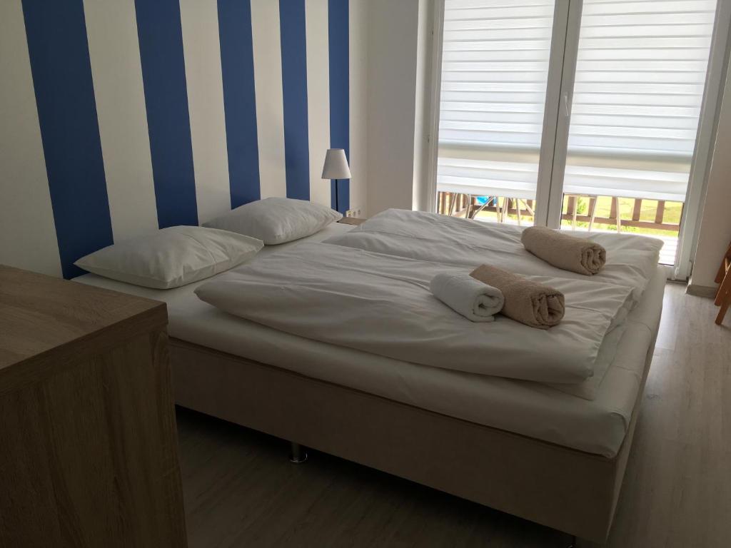 a large bed with two pillows on it in a bedroom at Apartamenty Owocowe in Rowy