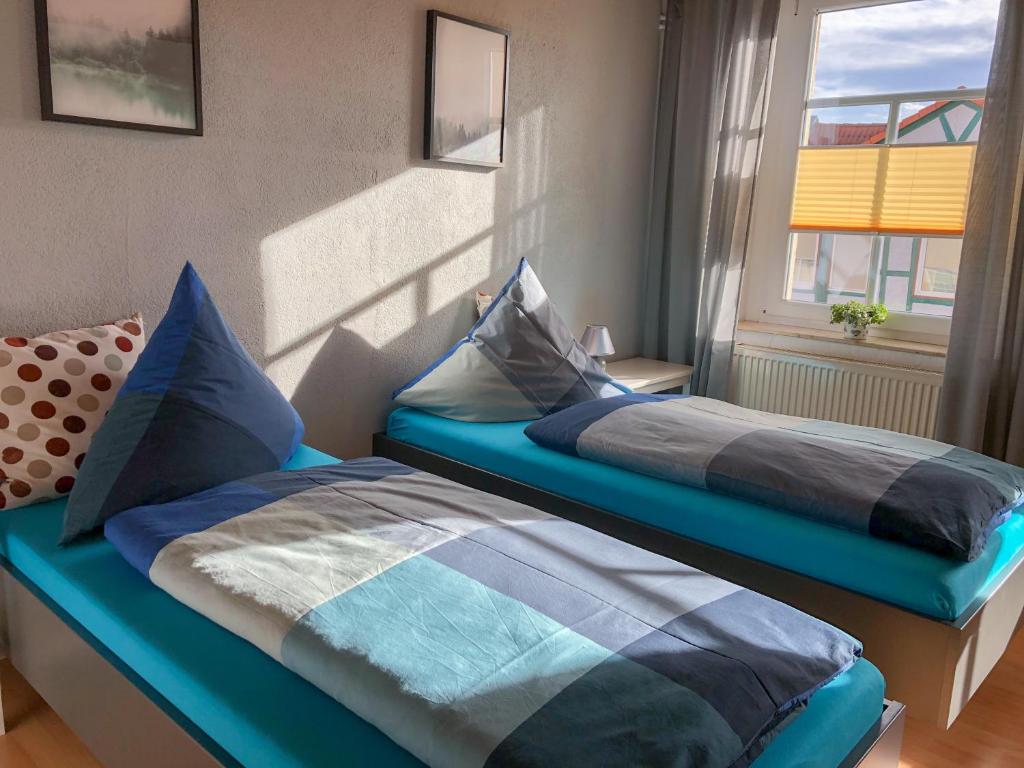 two beds sitting next to a window in a room at 100qm Ferienwohnung in Halberstadt, dem Tor zum Harz in Halberstadt