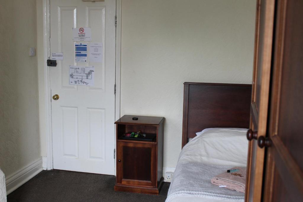 a small room with a bed and a door at Olympia Hotel in Selby