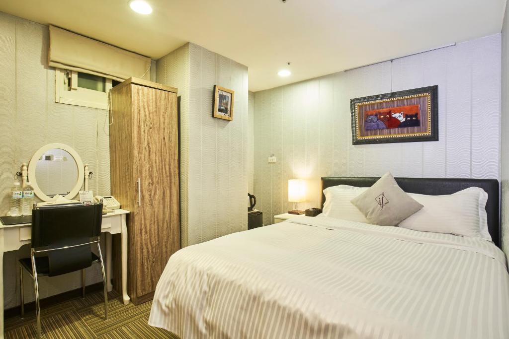 a bedroom with a bed and a desk and a mirror at 意芙旅店 Ifinn Hotel in Taipei