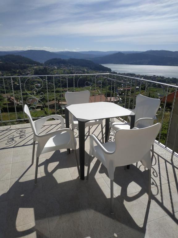 stół i krzesła na balkonie z widokiem w obiekcie Nores Buenavista 2 w mieście Vilaboa