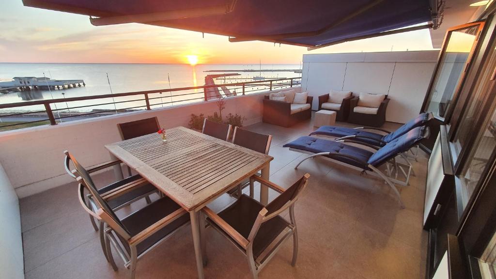 een tafel en stoelen op een balkon met uitzicht op de oceaan bij Takvåning - Borgholm in Borgholm