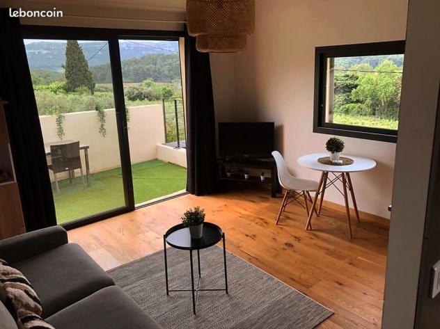 ein Wohnzimmer mit einem Sofa und einem Tisch in der Unterkunft Studio dans les vignes de cassis in Cassis