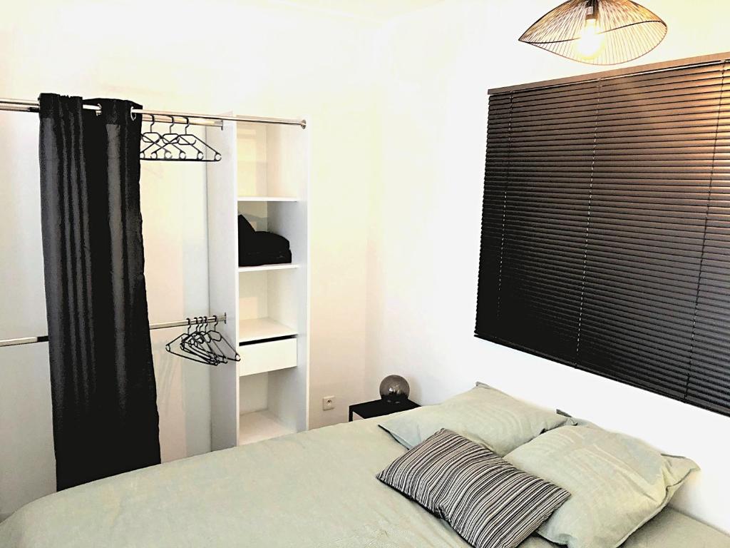 een slaapkamer met een bed met een zwart raam en een plank bij Appart 2 chambres gare St Charles in Marseille