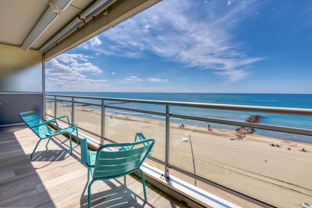 two chairs on a balcony looking out at the beach at Première ligne - Première conciergerie in Palavas-les-Flots