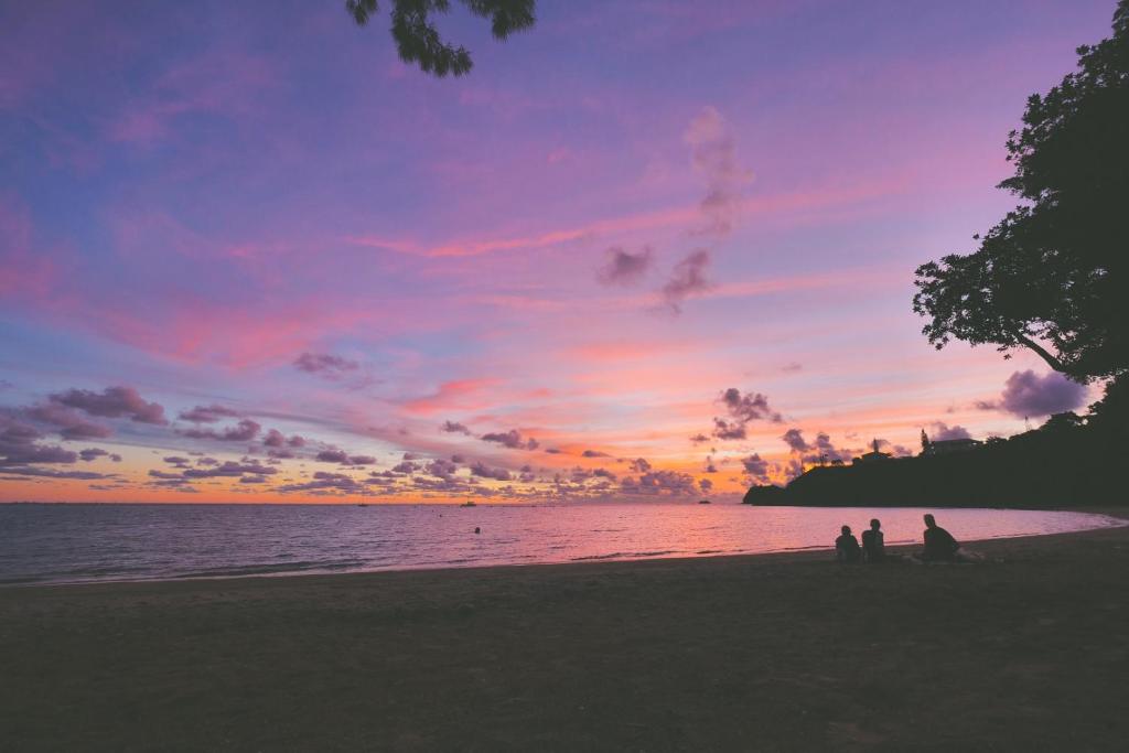 two people sitting on the beach watching the sunset at Hotel Beaurivage in Noumea