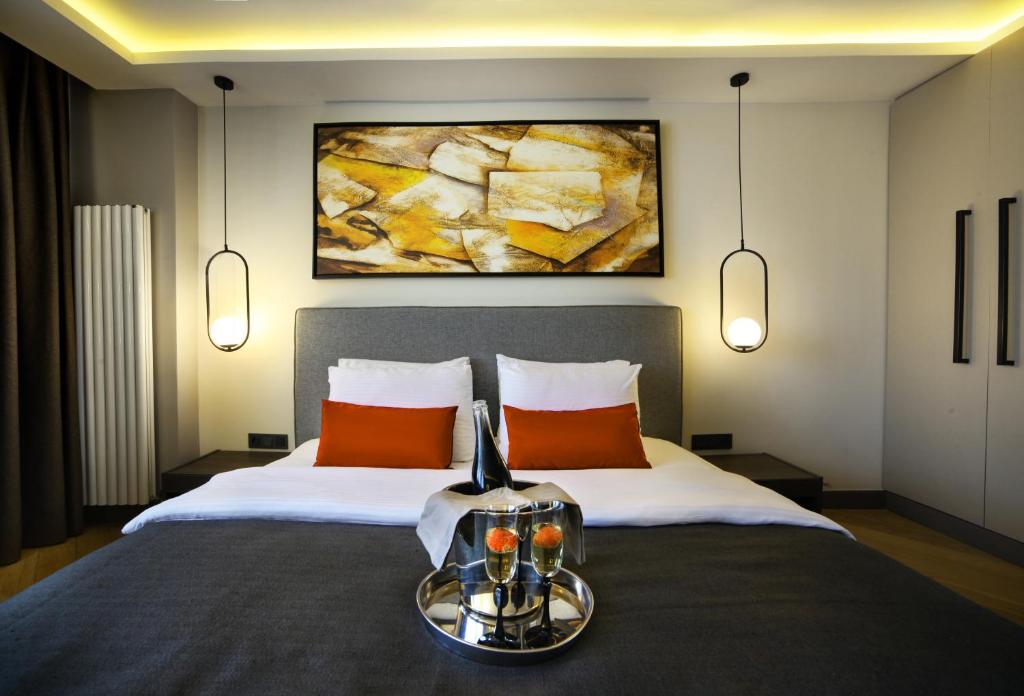 um quarto com uma cama grande e almofadas laranja em The Capital Hotel em Istambul