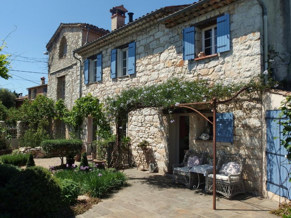 une ancienne maison en pierre avec un banc devant elle dans l'établissement Le Mas Saint Pierre, à Roquefort-les-Pins