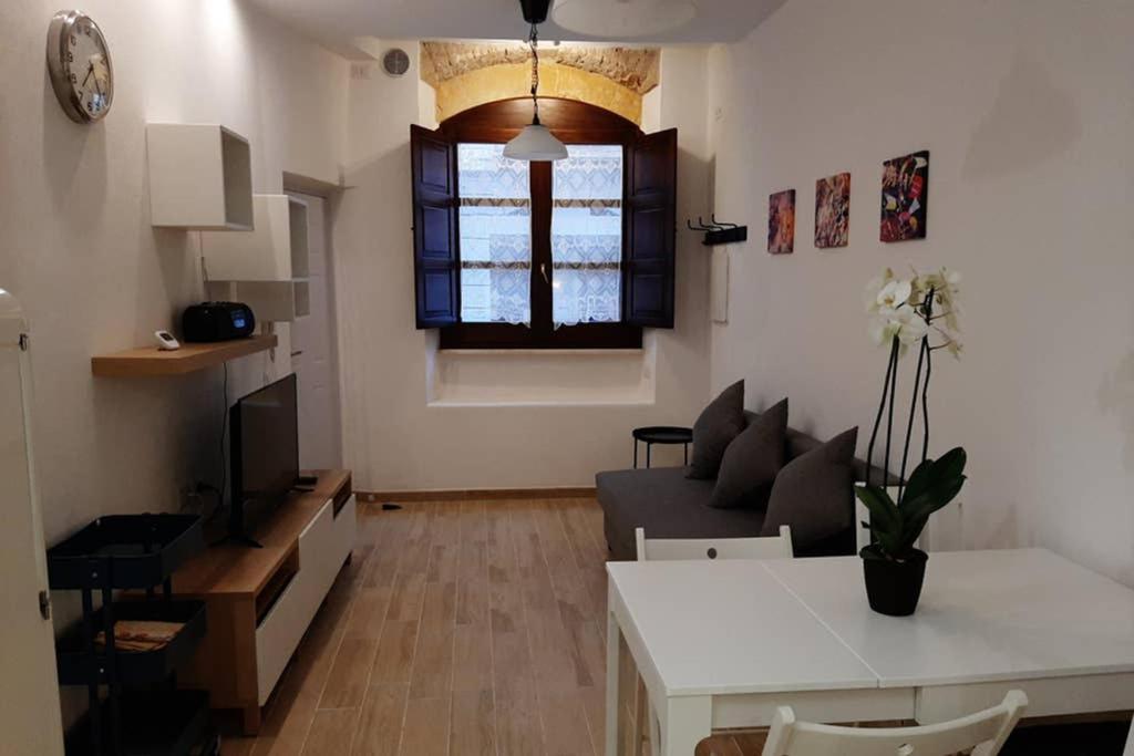salon z kanapą i stołem w obiekcie Casetta ALU' - il tuo nido a Stampace w Cagliari