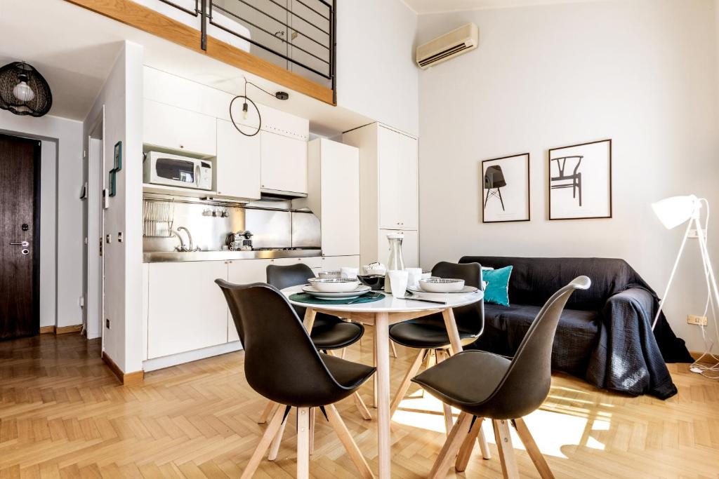 a dining room and living room with a table and chairs at Modern Simplicity in Milan Centre in Milan