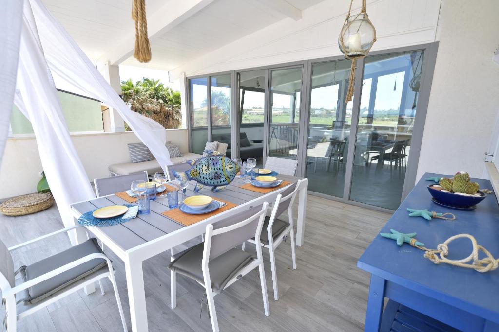 a dining room with a blue table and chairs at MARZAMEMI TERRAZZA VISTA MARE in Marzamemi