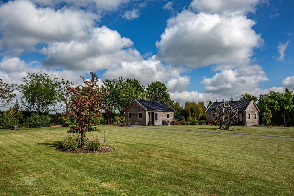 een groot veld met een huis en een windmolen bij Romala's Home 1 en 2 in Kiel