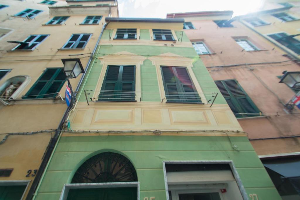 ein hohes, grünes Gebäude mit Seitenfenstern in der Unterkunft Appartamento a 3 passi dal mare in Varraze