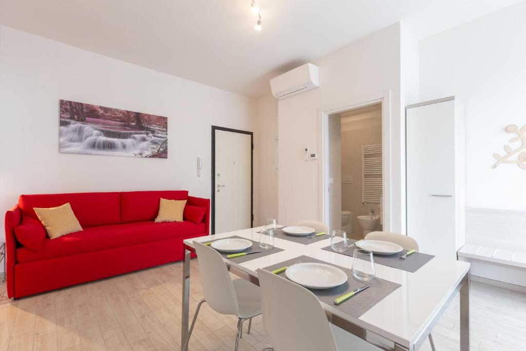 ein Wohnzimmer mit einem roten Sofa und einem Tisch in der Unterkunft Enjoy, Bologna by Short Holidays in Bologna