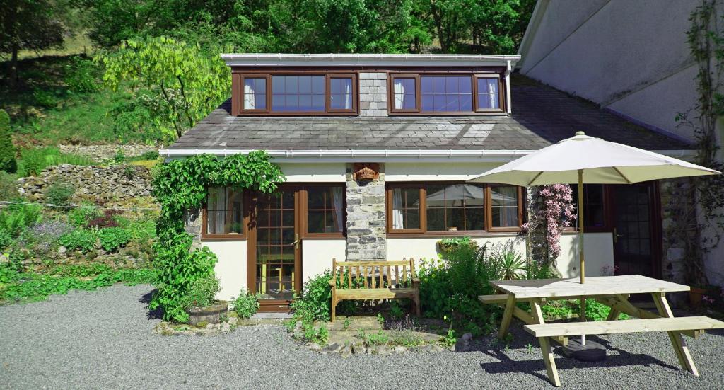 una piccola casa con tavolo e ombrellone di Kilsby Cottage a Llanwrtyd Wells