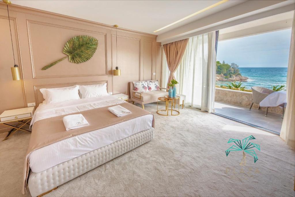 een slaapkamer met een groot bed en uitzicht op de oceaan bij Plaza Hotel&SPA in Ulcinj