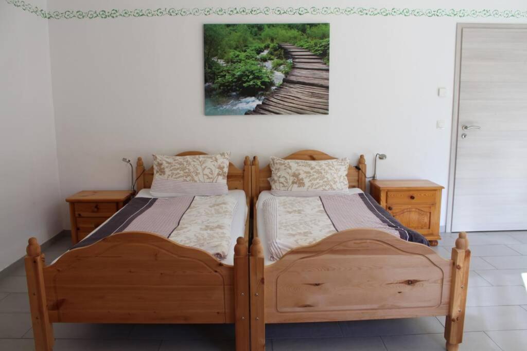 - 2 lits jumeaux dans une chambre avec une photo sur le mur dans l'établissement Appartment am Trätzhof, à Fulde