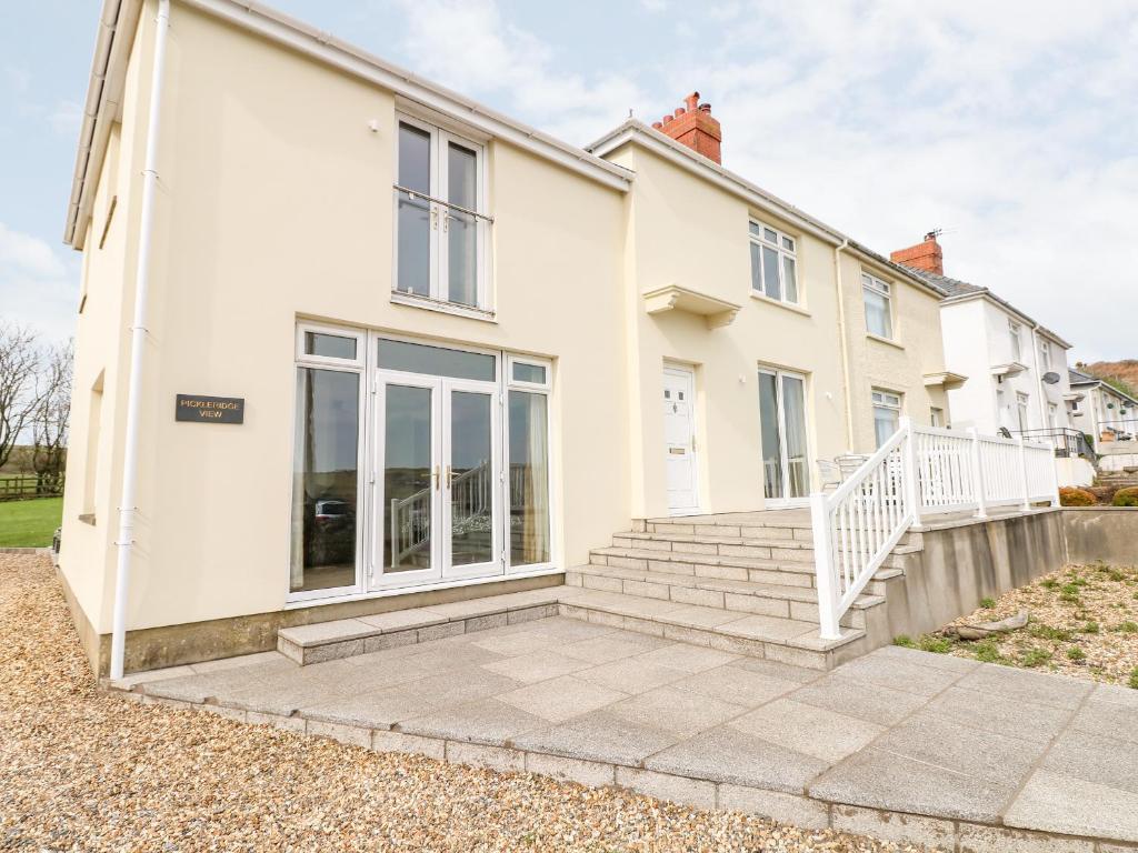a white house with a staircase in front of it at Pickleridge View in Haverfordwest