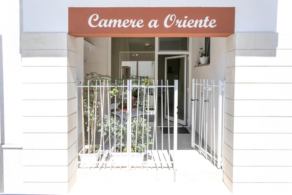 un frente de tienda con una puerta y un cartel que lee maneja un exterior en Camere a oriente, en Otranto