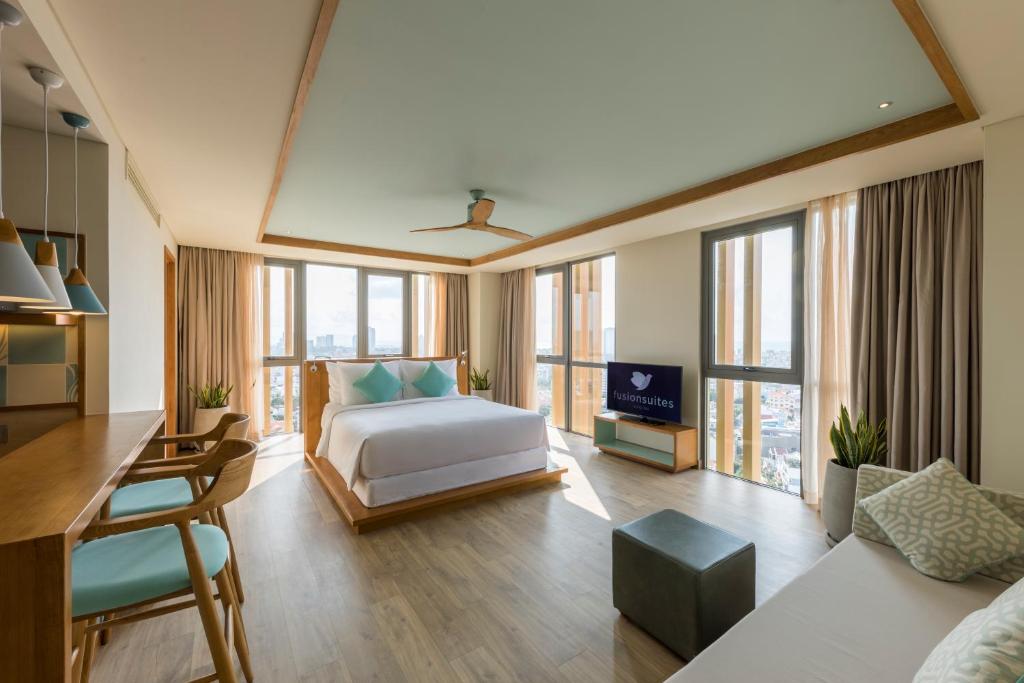 a bedroom with a bed and a living room at Fusion Suites Vung Tau in Vung Tau