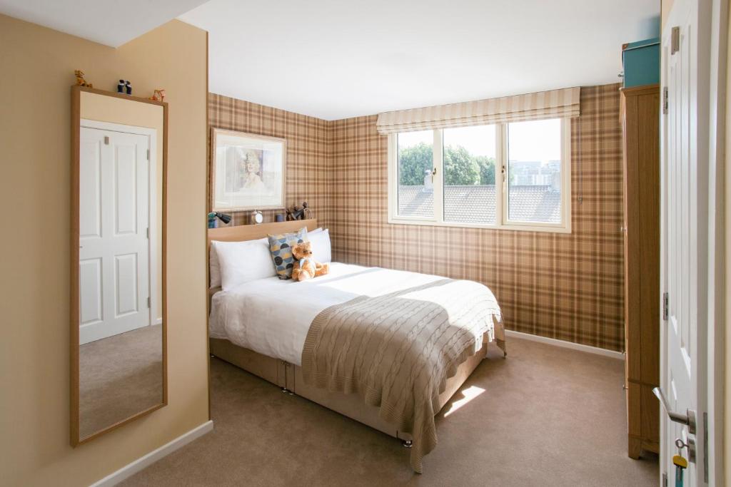 1 dormitorio con cama, ventana y espejo en 2 Mikes Homestay, en Dublín