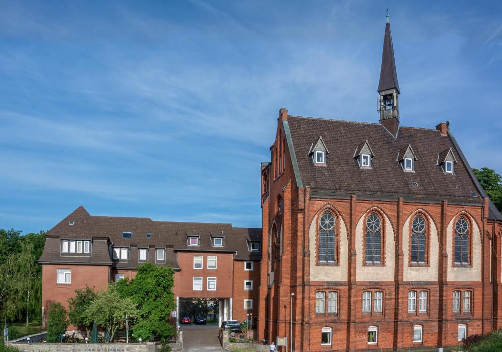 a large red brick building with a church at Hotel Klosterturm in Hildesheim