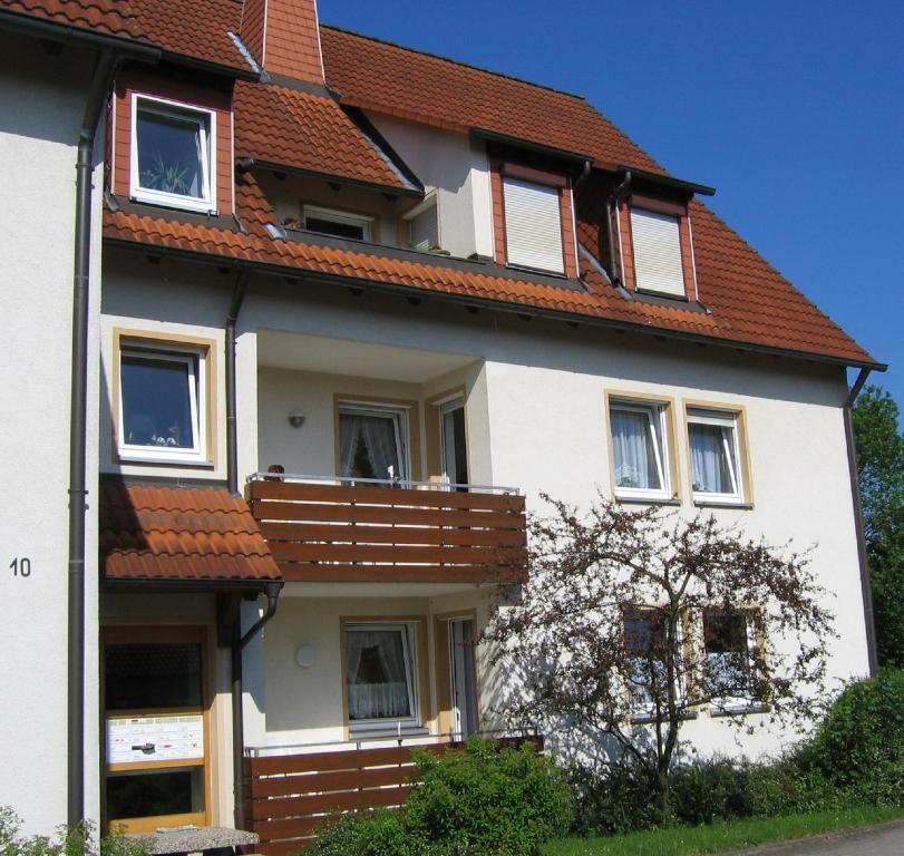ein weißes Haus mit rotem Dach in der Unterkunft Ferienwohnungen Müller in Bad Staffelstein