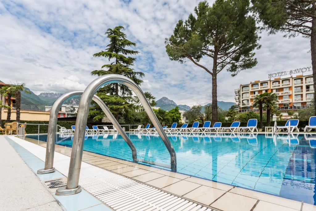 ein Pool mit Stühlen und ein Hotel in der Unterkunft Hotel Gardesana in Riva del Garda