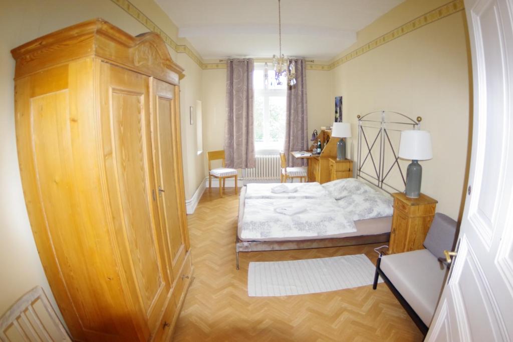 ロルヒ・アム・ラインにあるWohnen im Burghotelのベッドルーム1室(ベッド1台付)、大きな木製キャビネットが備わります。