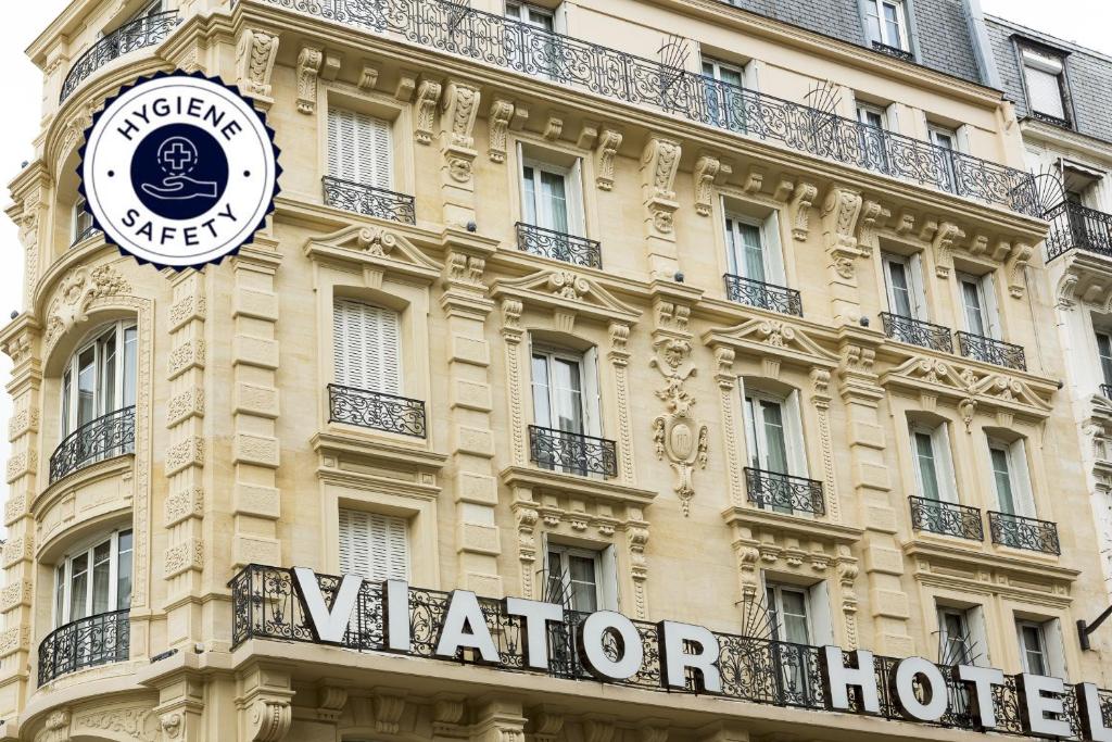 un bâtiment avec une horloge sur son côté dans l'établissement Hotel Viator - Gare de Lyon, à Paris