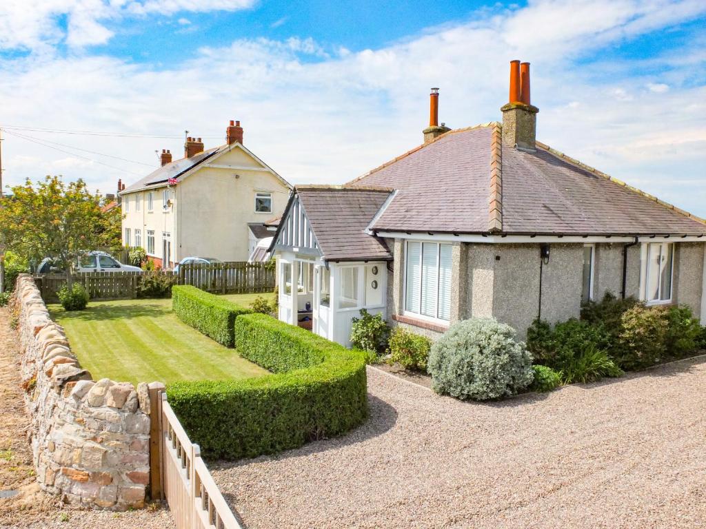 a house with a fence in front of it at Rosemary Cottage in Chathill