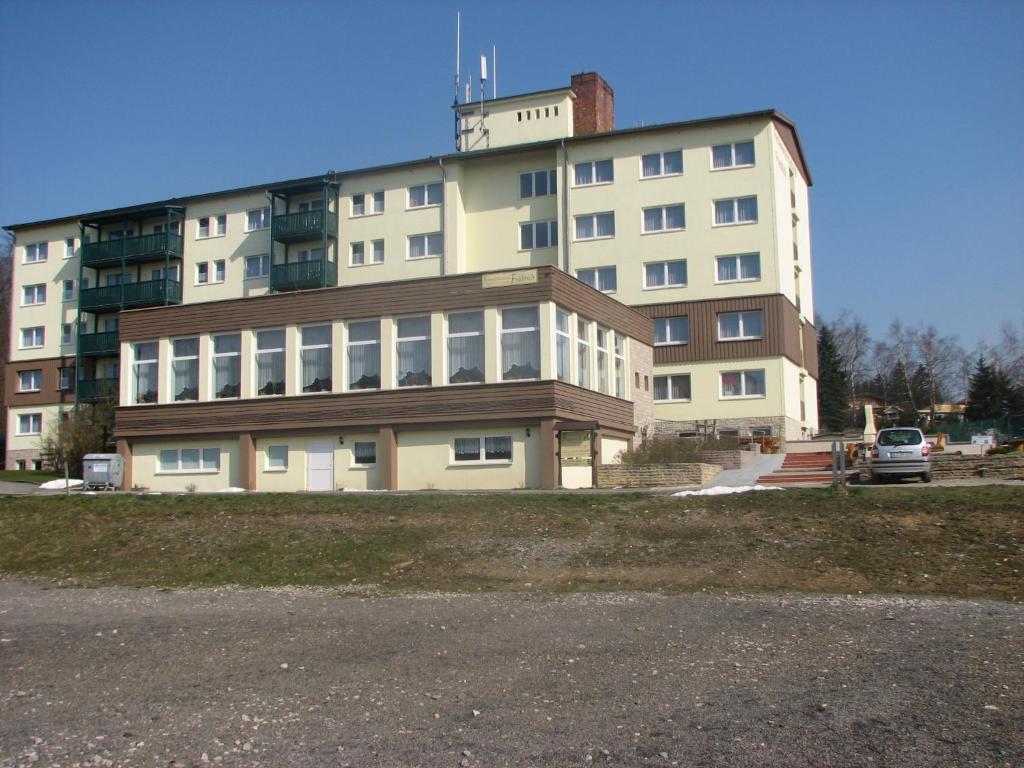 a large white building in front of a parking lot at Apartmenthotel-Harz in Friedrichsbrunn